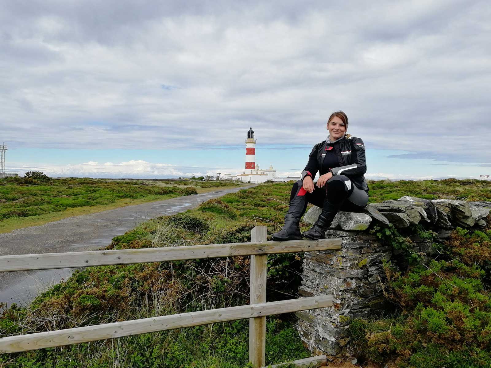 Nicole Ritter in Motorradkleidung mit Leuchtturm im Hintergrund